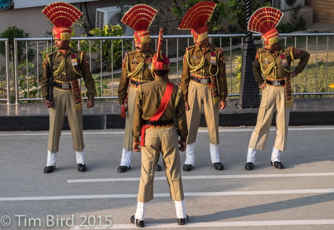 The ceremony of closing of the border with Pakistan near Amritsar has become a tourist attraction. The soldiers are staring towards Pakistan, where a similarly flamboyant guard contingent is staring back at them.