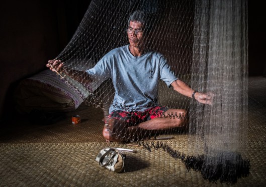 Mending nets at a Longhouse community in Sarawak, Borneo, Malaysia.
